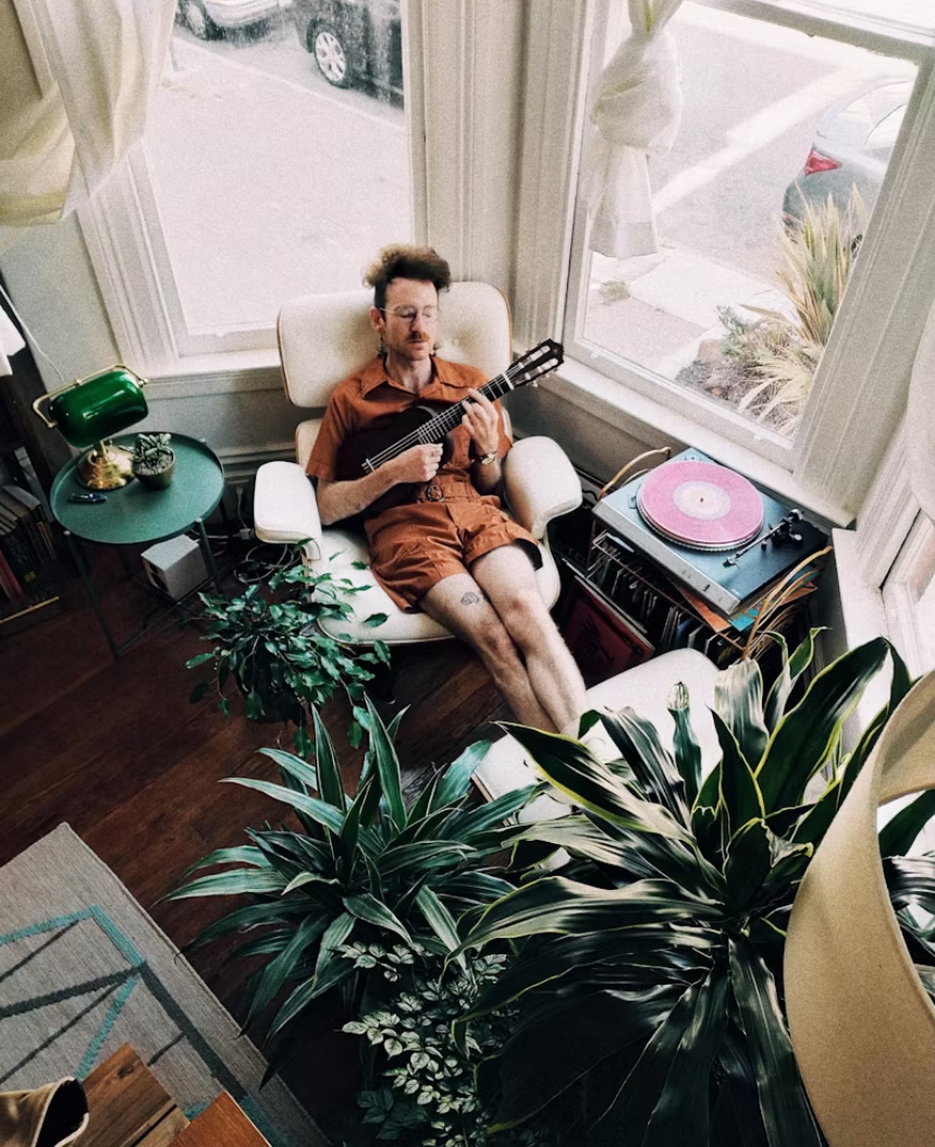 guy-playing-an-ukelele-in-a-chair
